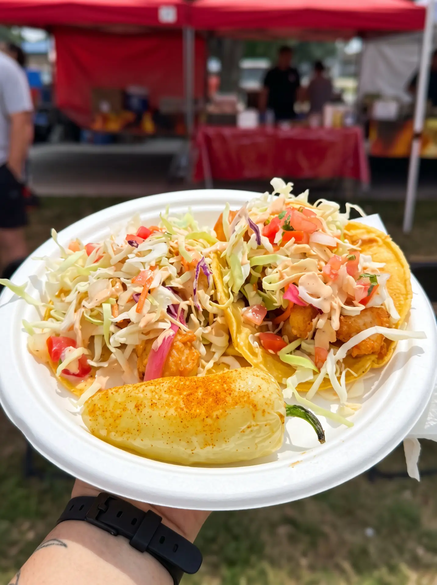 Shrimp tacos with cabbage slaw and a roasted chile on a plate