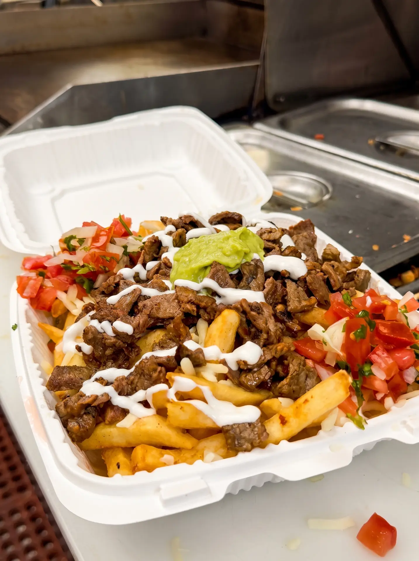 Carne asada fries with cheese, guacamole, crema and pico de gallo